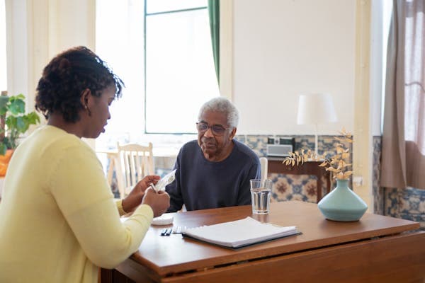 Care agency nurse assisting senior patient with daily activities